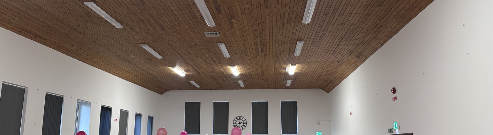 Inside the main hall at Bapchild & Tonge Village Hall — high pitched wooden ceiling and windows down one side